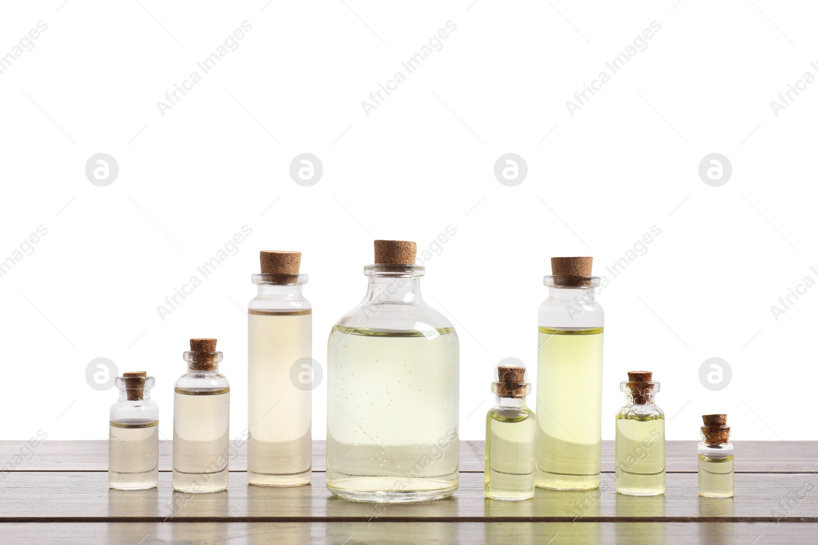 Photo of Bottles of essential oils on wooden table against white background