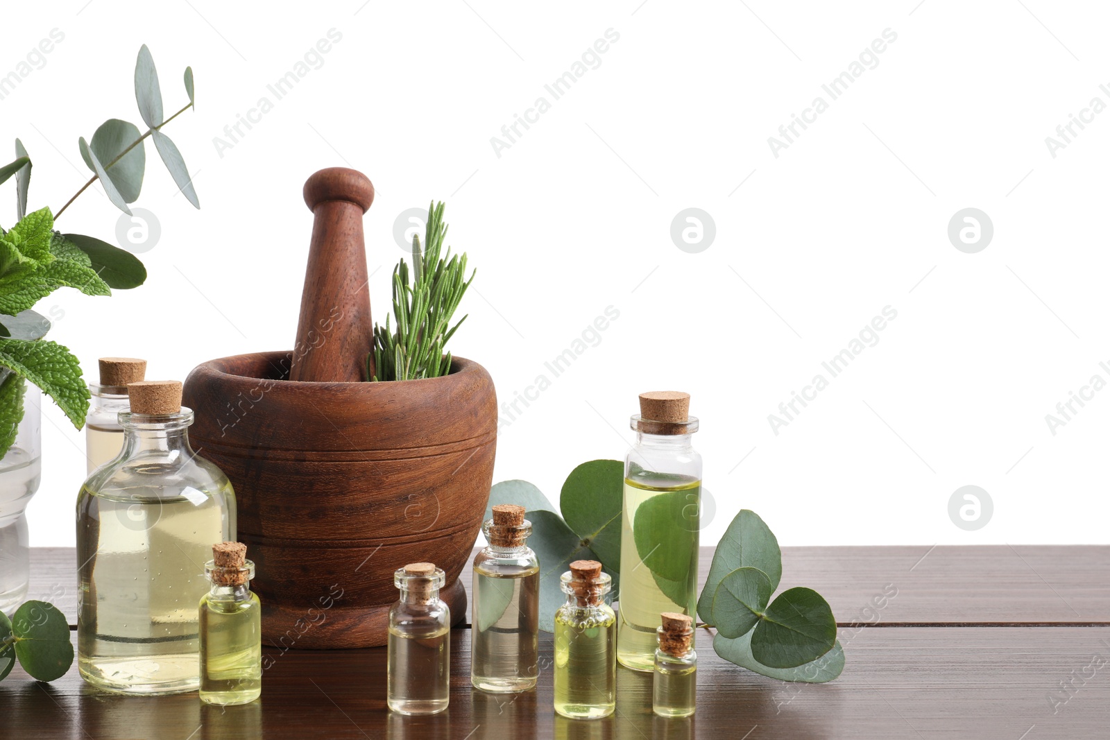 Photo of Bottles of essential oils and different plants on wooden table against white background