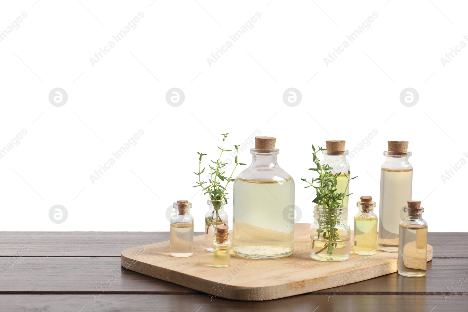 Photo of Bottles of essential oils and different herbs on wooden table against white background