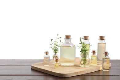 Photo of Bottles of essential oils and different herbs on wooden table against white background