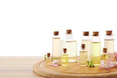 Photo of Bottles of essential oils and different plants on wooden table against white background