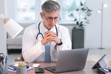 Photo of Telemedicine. Doctor having video call with patient via laptop indoors