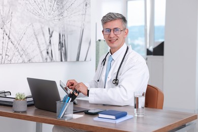Photo of Telemedicine. Doctor having video call with patient via laptop indoors
