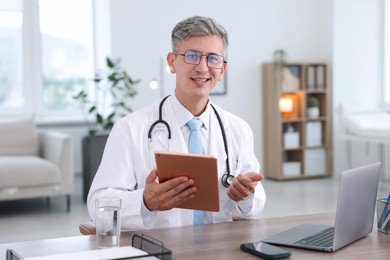 Photo of Telemedicine. Doctor having video call with patient via tablet indoors