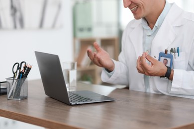 Photo of Telemedicine. Doctor having video call with patient via laptop indoors, closeup