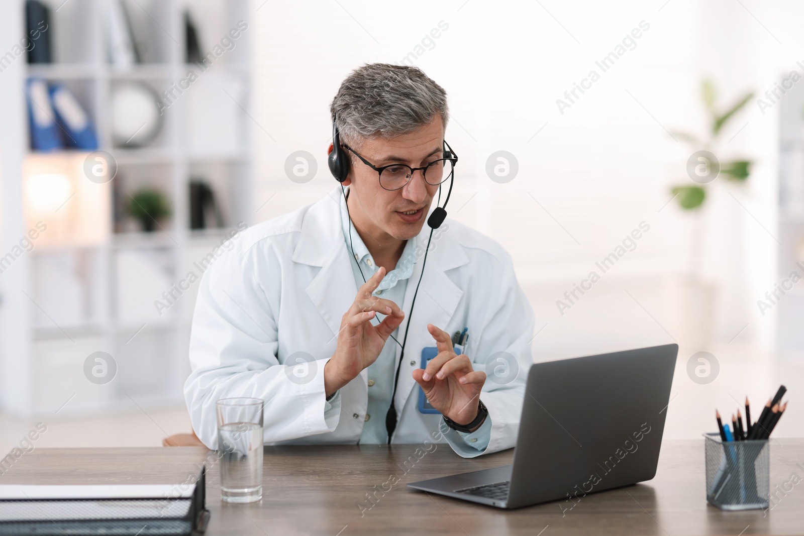 Telemedicine. Doctor having video call with patient via laptop indoors Photo of Telemedicine. Doctor having video call with patient via laptop indoors