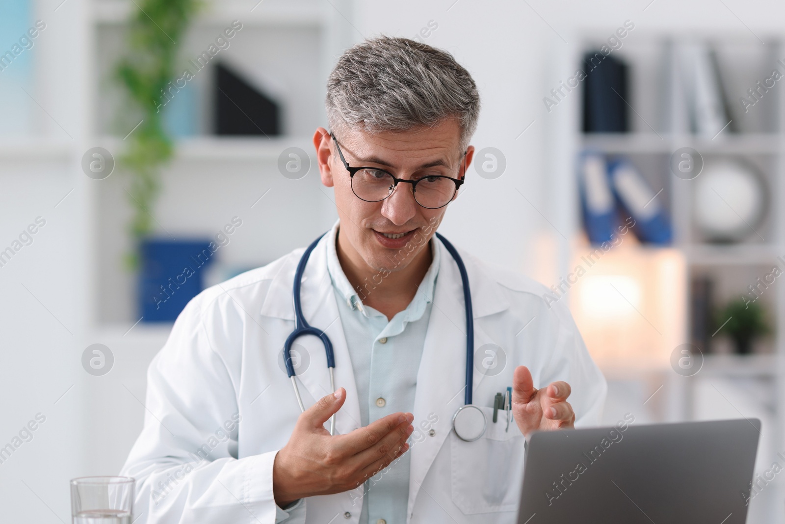 Telemedicine. Doctor having video call with patient via laptop indoors Photo of Telemedicine. Doctor having video call with patient via laptop indoors
