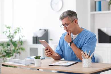 Photo of Telemedicine. Doctor having video call with patient via tablet indoors