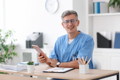 Photo of Telemedicine. Doctor having video call with patient via tablet indoors