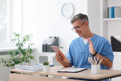Photo of Telemedicine. Doctor having video call with patient via tablet indoors