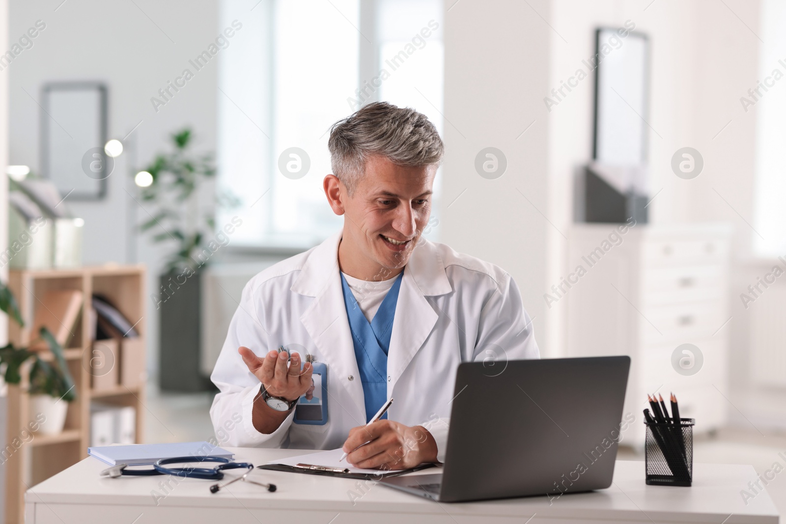 Telemedicine. Doctor having video call with patient via laptop indoors Photo of Telemedicine. Doctor having video call with patient via laptop indoors