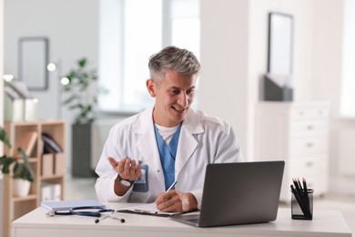 Photo of Telemedicine. Doctor having video call with patient via laptop indoors