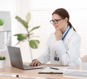 Photo of Telemedicine. Doctor having video call with patient via laptop indoors