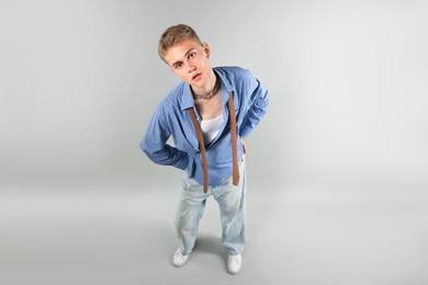 Photo of Handsome young man wearing stylish clothes on light grey background, above view