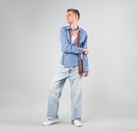 Photo of Handsome young man wearing stylish clothes on light grey background
