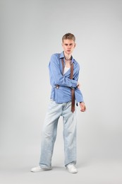 Photo of Handsome young man wearing stylish clothes on light grey background