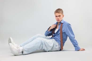 Photo of Handsome young man wearing stylish clothes on light grey background