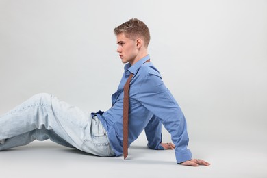 Photo of Handsome young man wearing stylish clothes on light grey background