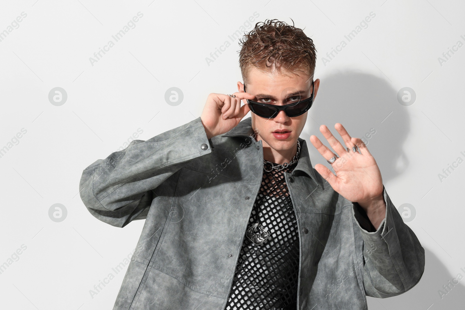 Photo of Handsome young man wearing stylish jacket and sunglasses on white background