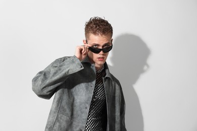 Photo of Handsome young man wearing stylish jacket and sunglasses on white background