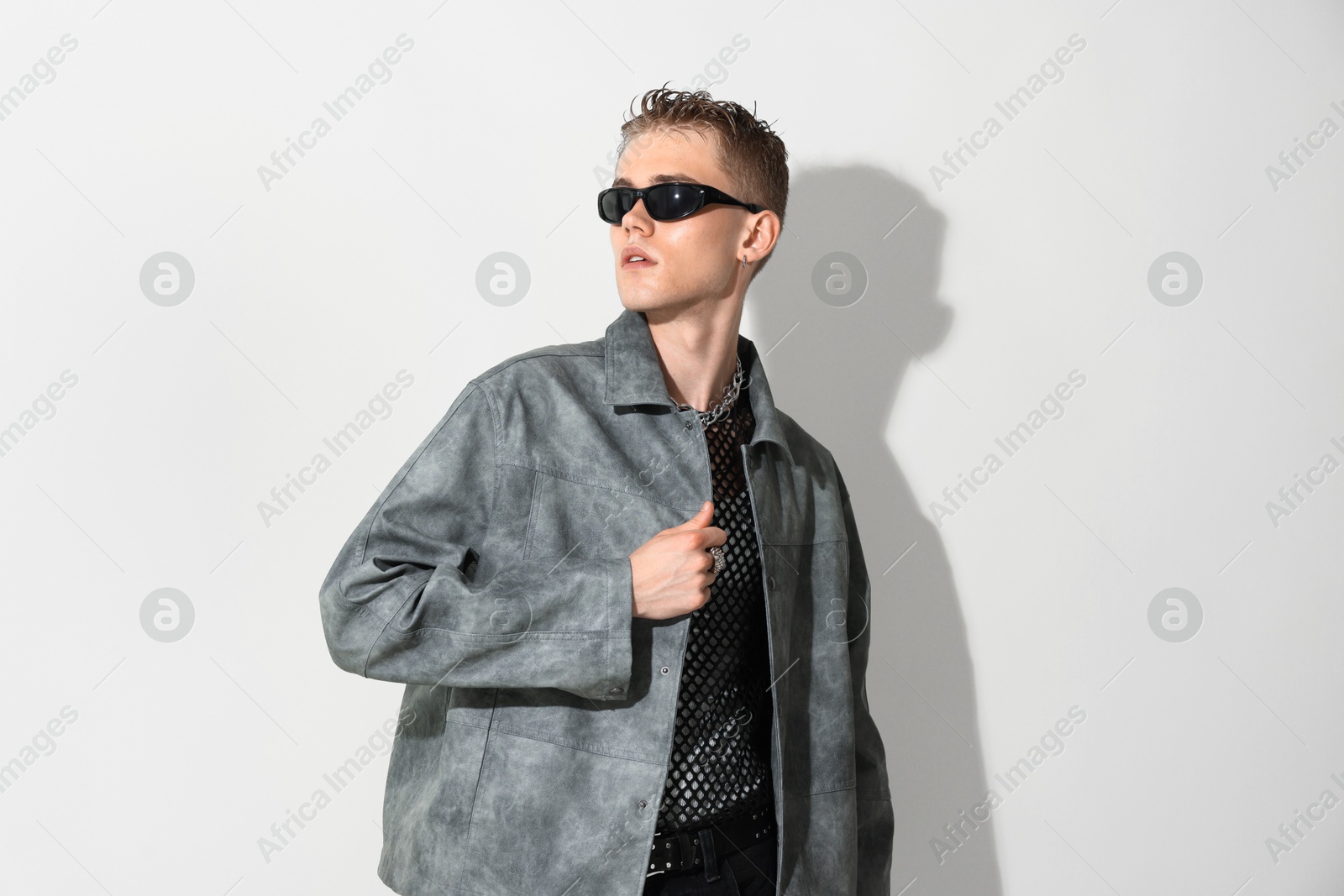 Photo of Handsome young man wearing stylish jacket and sunglasses on white background