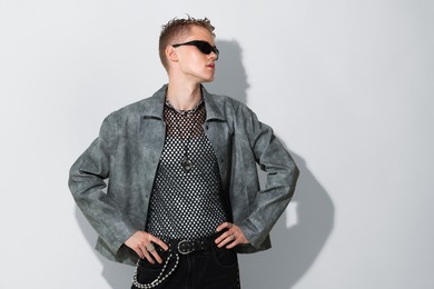 Photo of Handsome young man wearing stylish jacket and sunglasses on white background