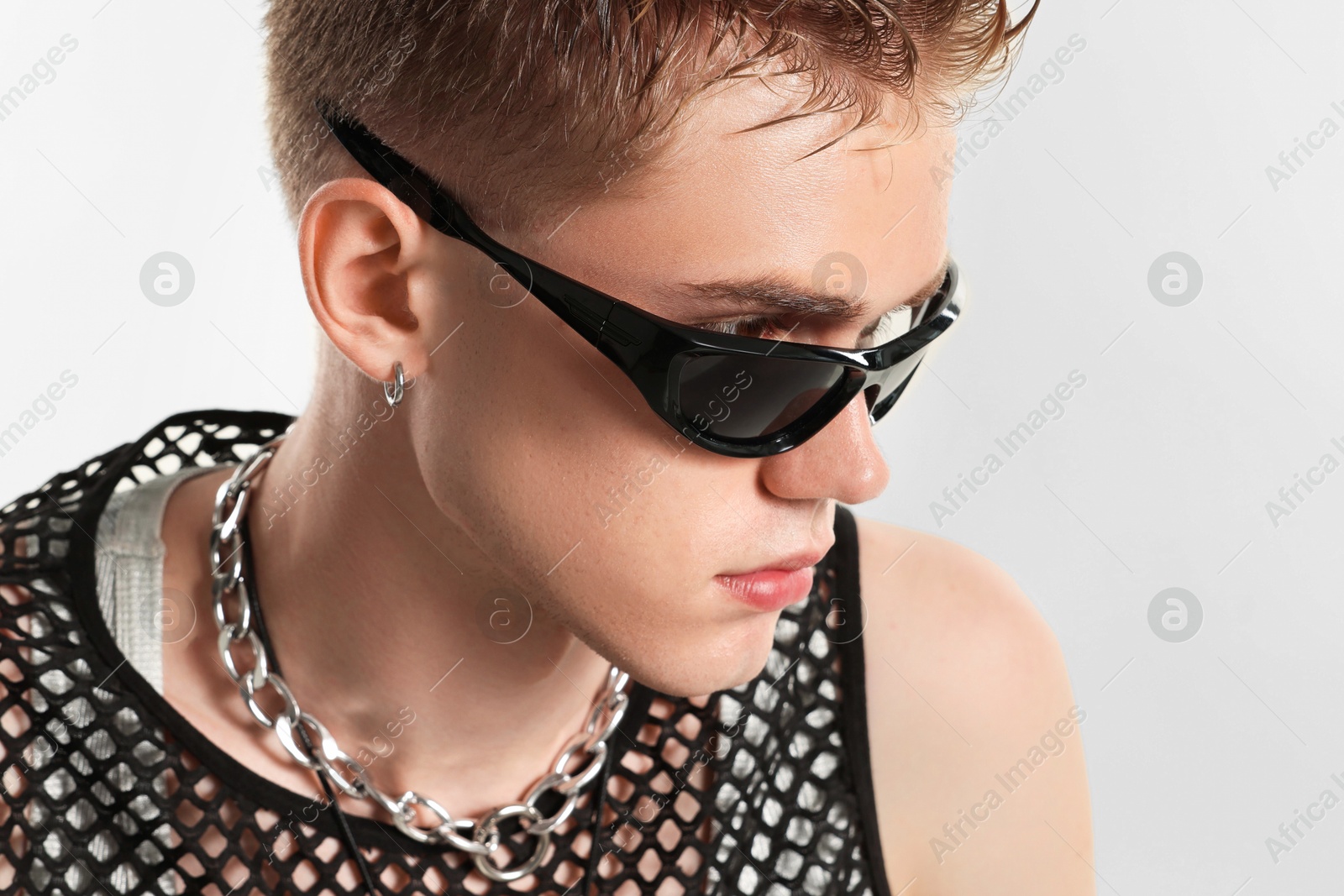 Photo of Handsome young man wearing sunglasses on white background