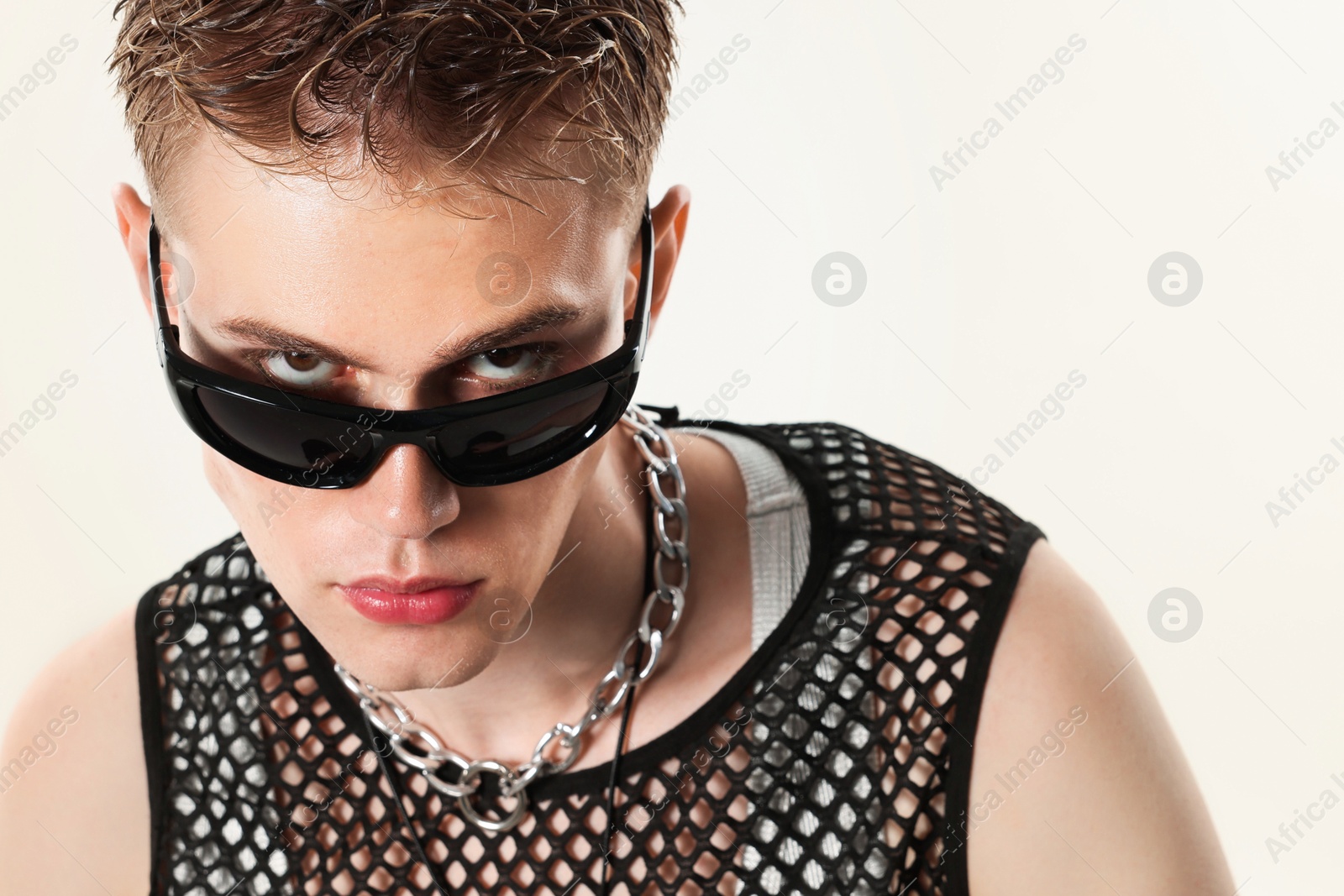 Photo of Handsome young man wearing sunglasses on white background