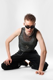 Photo of Handsome young man wearing sunglasses on white background