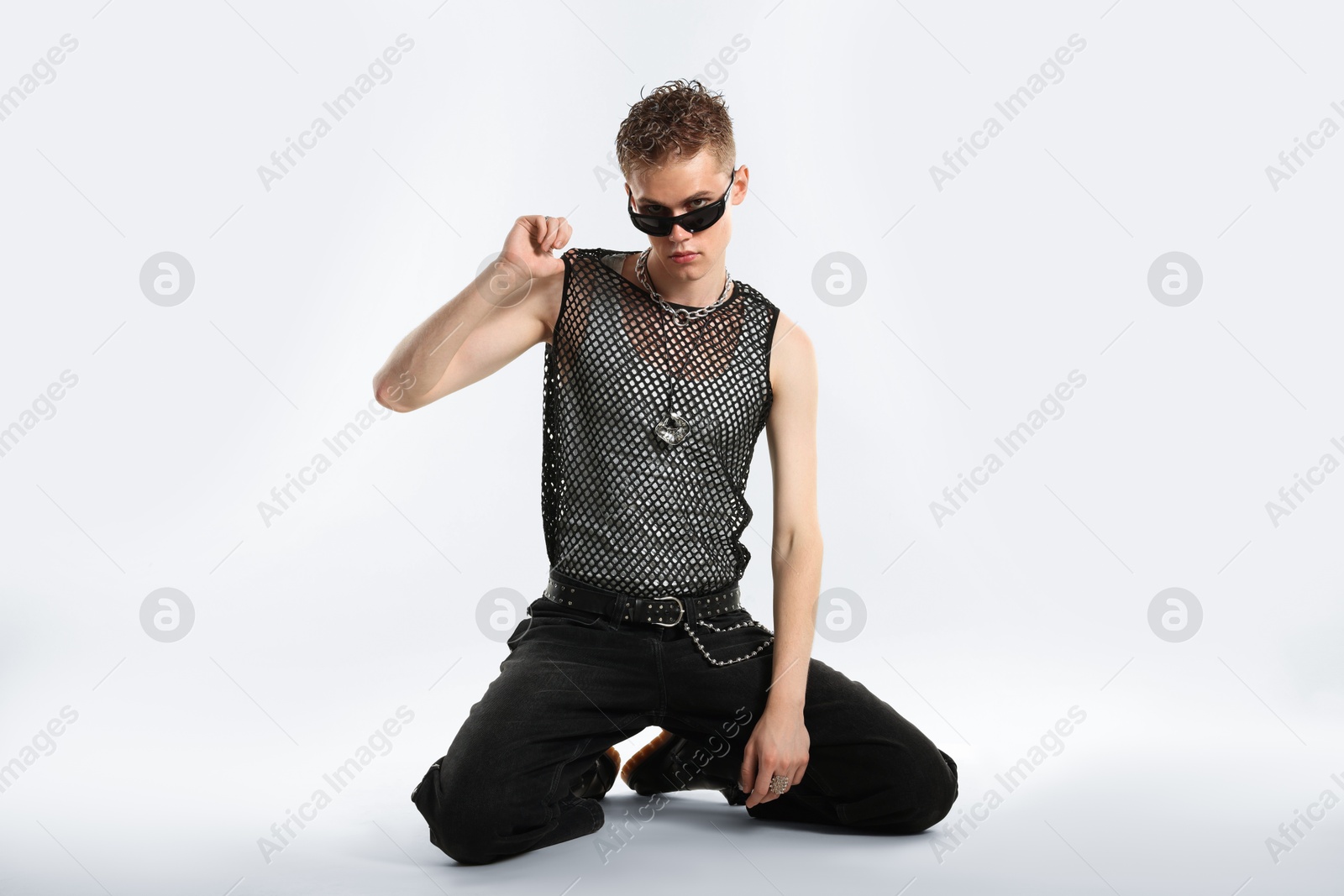 Photo of Handsome young man wearing sunglasses on white background