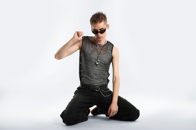 Photo of Handsome young man wearing sunglasses on white background