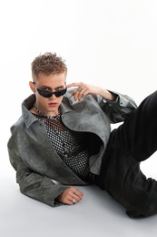 Photo of Handsome young man wearing stylish jacket and sunglasses on white background