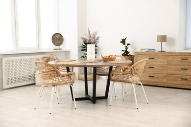 Photo of Stylish table with chairs and decor in dining room. Interior design