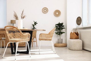 Photo of Stylish table with chairs and decor in dining room. Interior design