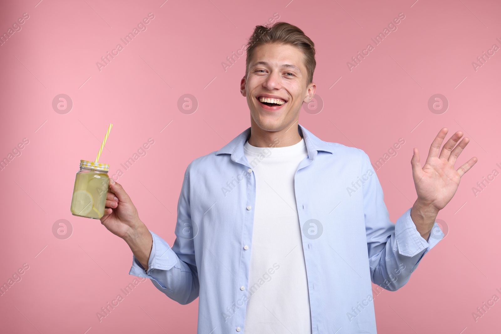 Happy man with mason jar of lemonade on pink background. Refreshing drink Photo of Happy man with mason jar of lemonade on pink background. Refreshing drink