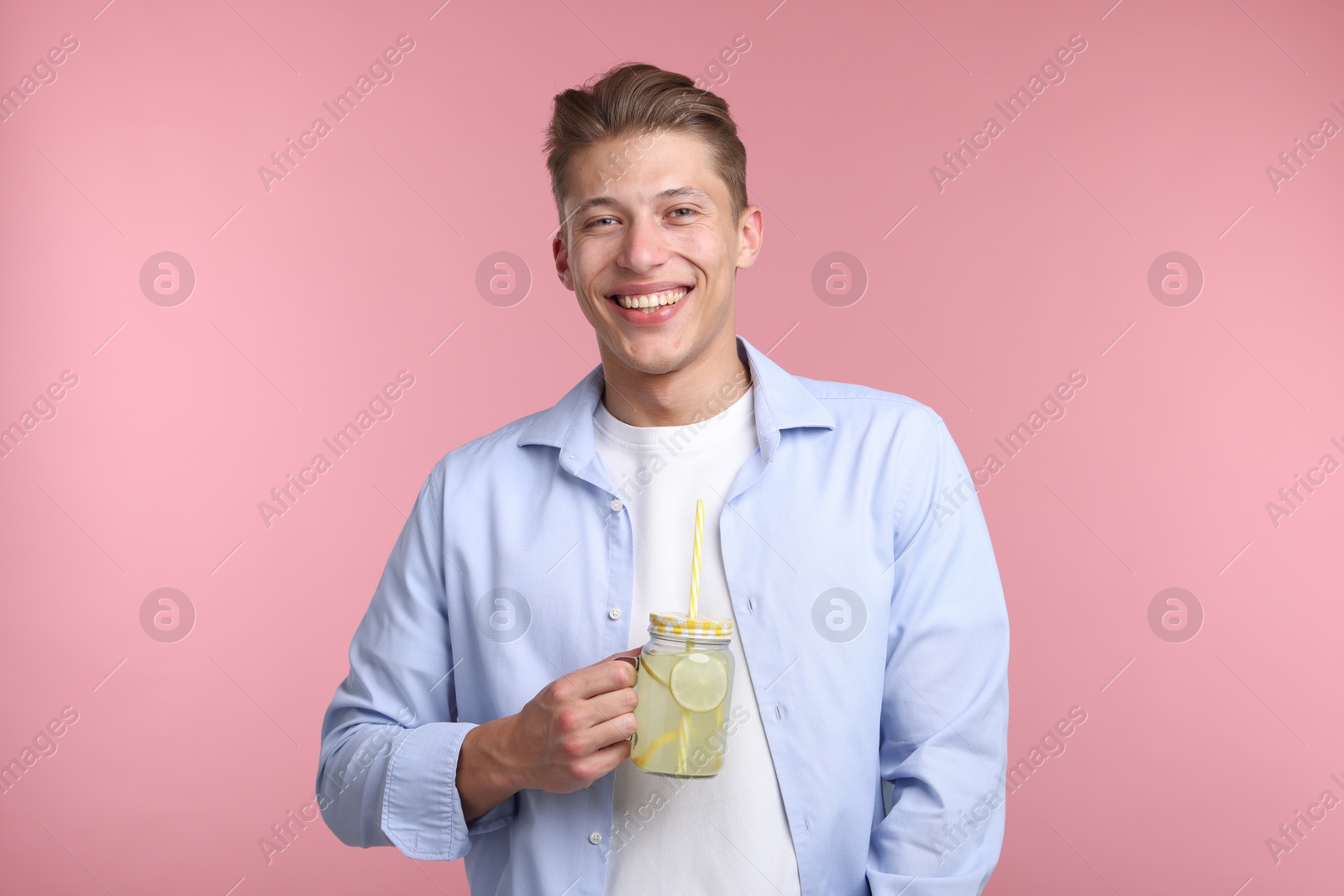 Happy man with mason jar of lemonade on pink background. Refreshing drink Photo of Happy man with mason jar of lemonade on pink background. Refreshing drink