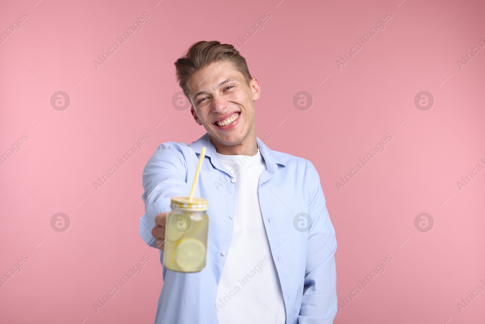 Happy man with mason jar of lemonade on pink background. Refreshing drink Photo of Happy man with mason jar of lemonade on pink background. Refreshing drink