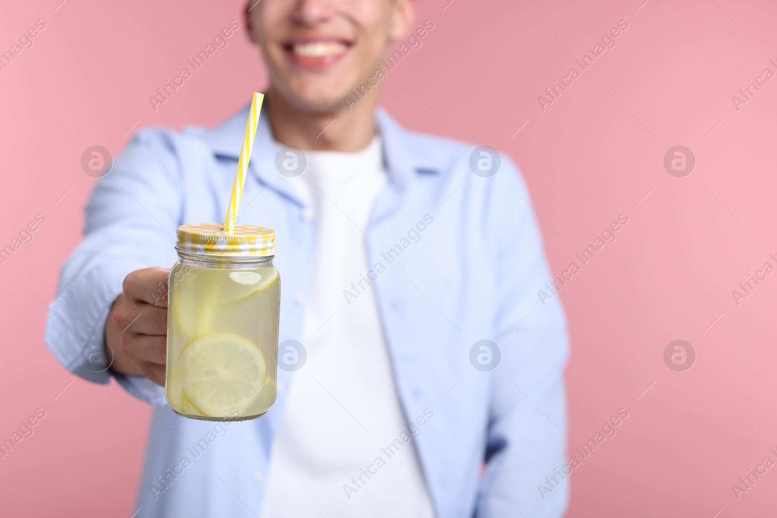 Happy man with mason jar of lemonade on pink background, closeup. Refreshing drink Photo of Happy man with mason jar of lemonade on pink background, closeup. Refreshing drink