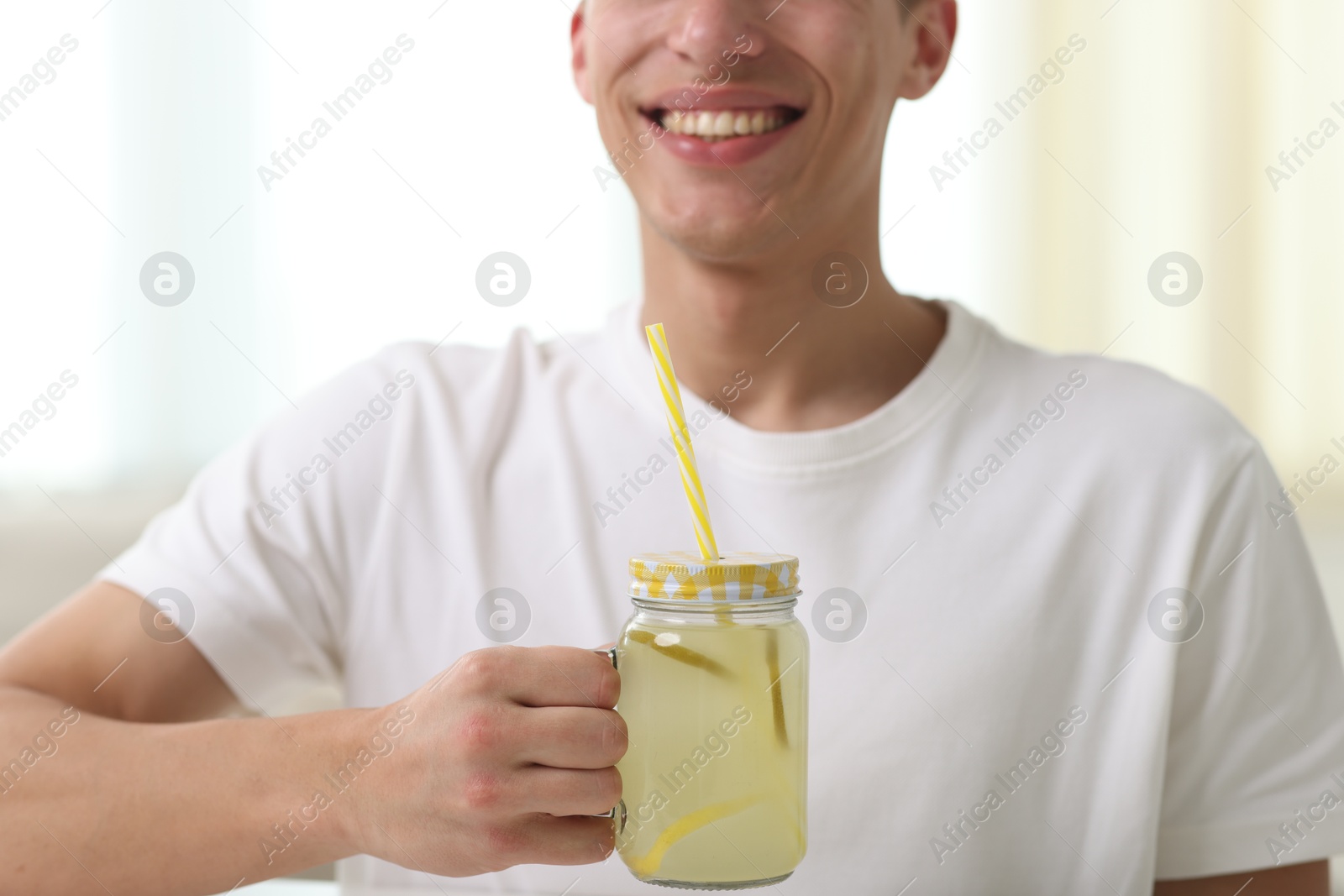 Happy man with mason jar of lemonade at home, closeup. Refreshing drink Photo of Happy man with mason jar of lemonade at home, closeup. Refreshing drink