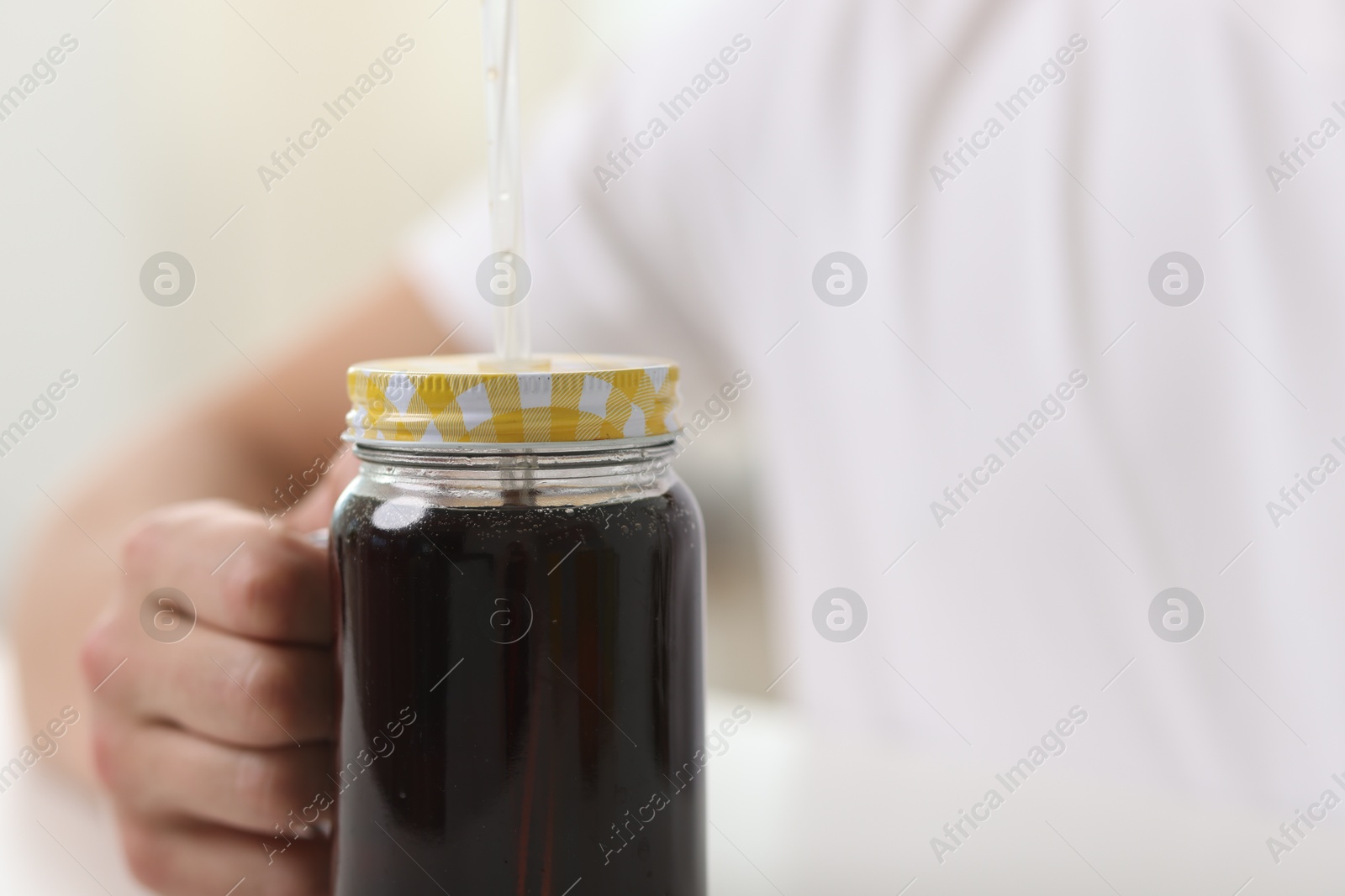 Man with mason jar of refreshing soda drink on blurred background, closeup Photo of Man with mason jar of refreshing soda drink on blurred background, closeup
