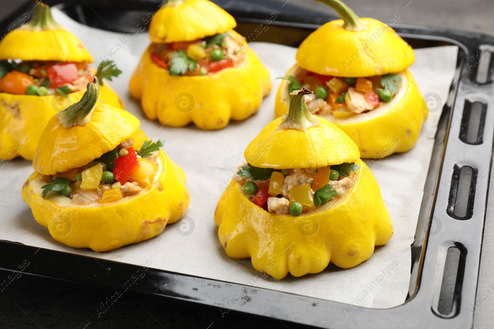 Photo of Tasty stuffed pattypan squashes on dark table, closeup