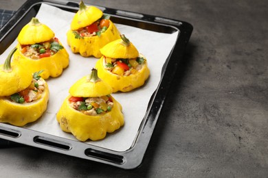 Photo of Tasty stuffed pattypan squashes on dark textured table, closeup