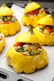 Photo of Tasty stuffed pattypan squashes on baking sheet, closeup