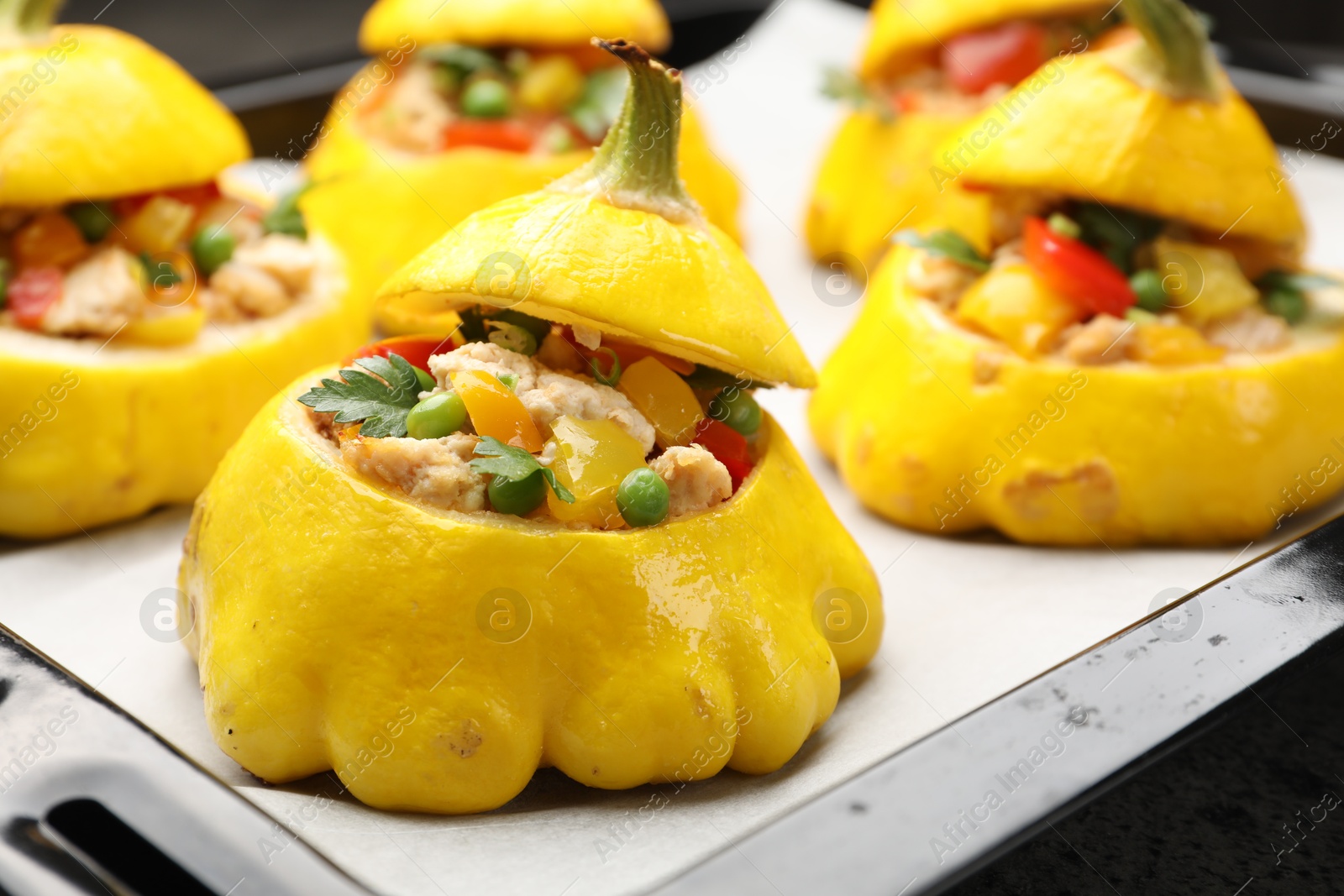 Photo of Tasty stuffed pattypan squashes on baking sheet, closeup