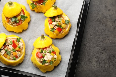 Photo of Tasty stuffed pattypan squashes on dark textured table, top view