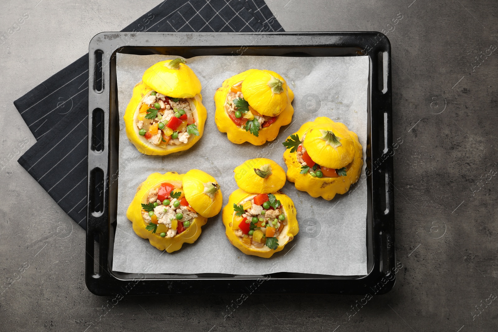 Photo of Tasty stuffed pattypan squashes on dark textured table, top view