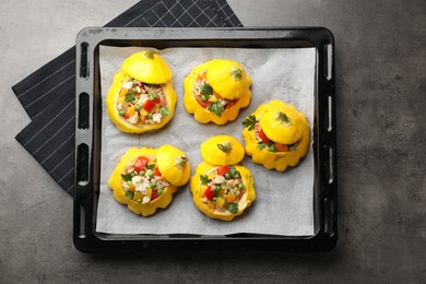 Photo of Tasty stuffed pattypan squashes on dark textured table, top view