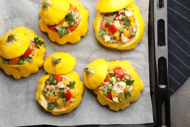 Photo of Tasty stuffed pattypan squashes on dark textured table, top view