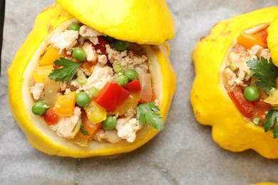 Photo of Tasty stuffed pattypan squashes on baking paper, top view