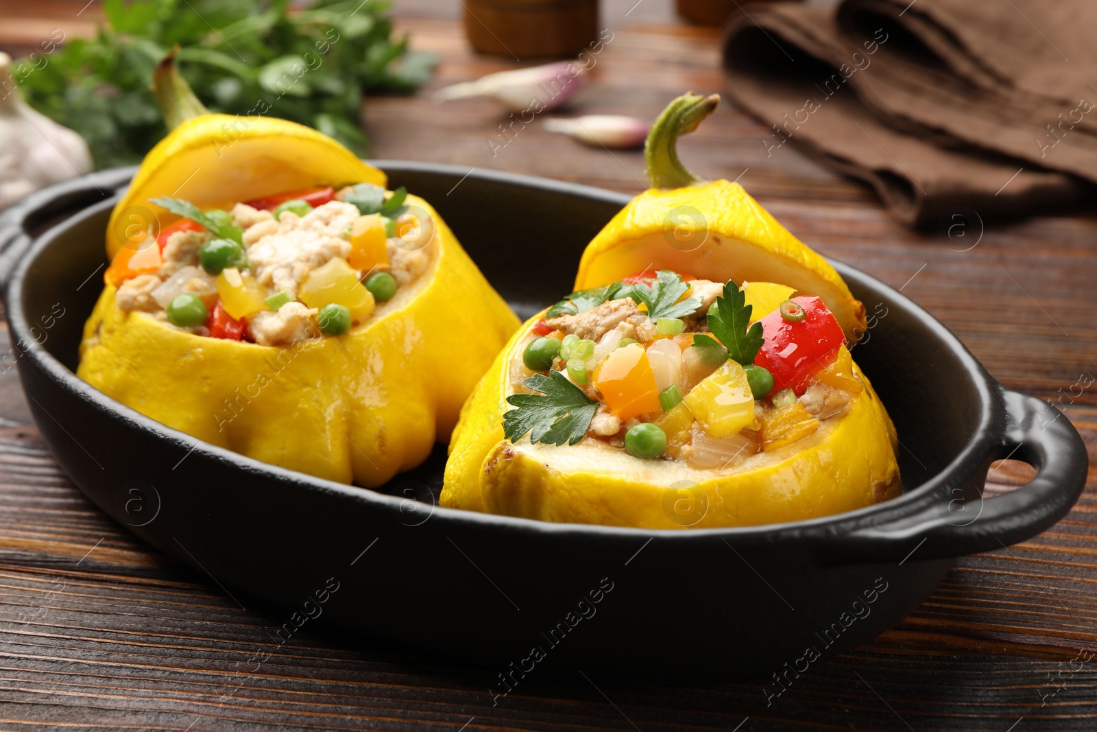 Tasty stuffed pattypan squashes in baking dish on wooden table, closeup Photo of Tasty stuffed pattypan squashes in baking dish on wooden table, closeup